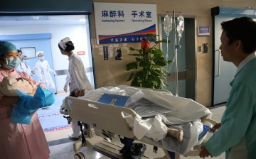A patient is wheeled into a hospital room in Nanning, Guangxi Province, on Nov. 27, 2014.