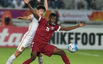 China's Wang Tong (L) competes with Qatar's Mohammed Muntari during their AFC U23 Championship Group A match.