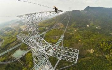 Electricians work on a 1,680-kilometer-long high-voltage DC transmission line in Zhejiang Province.