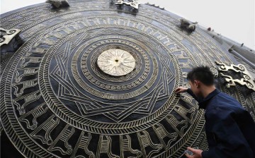 A worker cleans the surface of the bronze drum on Dec. 15, 2015. 
