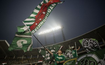 A fan waves a Beijing Guoan flag.