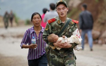 A paramilitary policeman carries a baby in his arms after an earthquake hit Ludian county of Zhaotong, Yunnan Province, Aug. 3, 2014.