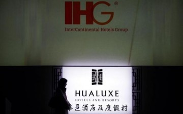 A woman walks past a hotel sign in Beijing where recently hotels received various awards in 