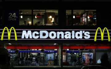 Customers are seen through the windows of a McDonald's store (top) in Tokyo, while others stand in line in front of cash registers, July 22, 2014. 