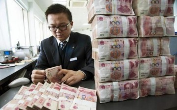 A clerk counts Chinese 100 yuan banknotes at a branch of China Construction Bank in Nantong, Jiangsu Province, Dec. 2, 2014.