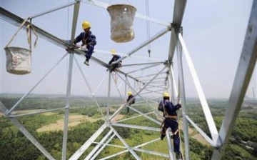 Workers install a high-voltage pylon in Anhui Province as China plans to build a 