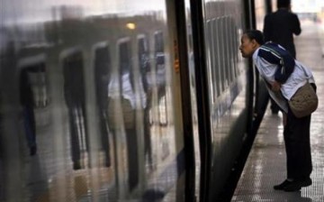 A passenger peers into a train in a railway station in Zhengzhou City in Henan Province named by Amazon as China's most romantic city.