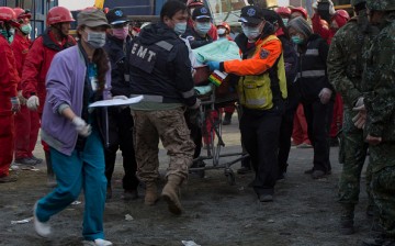 Rescue workers use a stretcher to take a victim to an ambulance at the site of a collapsed building in Tainan, Taiwan, on Feb. 7, 2016. 