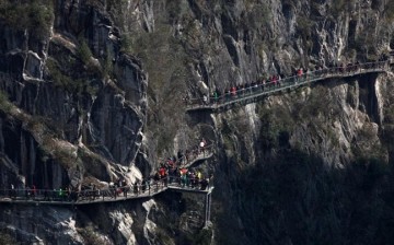 Tourists flock the walkway in Chongqing Qianjiang, apparently not minding much the daunting location and dizzying height.