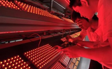 Employees measure the aging levels of low-energy consumption LED light bulbs at a factory in Nanjing, Jiangsu Province, May 18, 2012. 