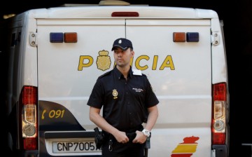  A policeman stands guard at a police van in Madrid, Spain, on Sept. 1, 2014. 