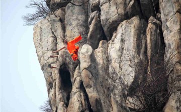 Shaolin kung fu masters practice on a cliff at Songshan Mountain in Dengfeng, Central China's Henan Province, March 17, 2016. 