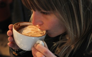 A young woman samples freshly brewed cappuccino at Bonanza Coffee Roasters on Jan. 24, 2011, in Berlin, Germany.