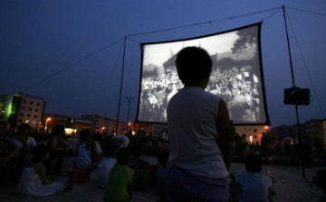 People watch a free movie at an open-air cinema at a square after an earthquake in Wen'an County, Hebei Province of China on July 4, 2006.