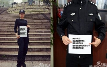 Perhaps the paper will be colored--or bigger--next time? Two police officers from Yibin in Sichuan Province pose for picture together with an important public message.