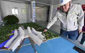 A worker introduces the construction progress of the National Maritime Museum in Tianjin, north China, April 5, 2016. 