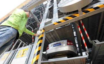 A technician demonstrates how to park cars under the automatic system in a multi-story parking garage in Tongzhou District of Beijing, April 5, 2016.