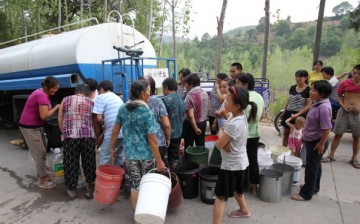 Villagers crowd around to receive water in Luoyang, Henan Province, on Aug. 4, 2014.
