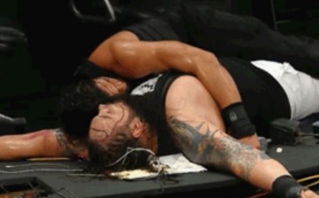 Roman reigns and  Bray Wyatt lay on the ruins of a table during a WWE hell-in-a-cell match in 2015.