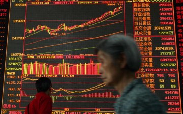 An investor walks past an electronic screen displaying stock index at a securities company in Wuhan, Hubei Province, China, on May 8, 2007. 