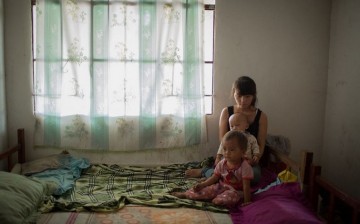 Not siblings: Xiao Mei, 16, holds her 1-year-old son as they and her 2-year-old daughter pose for a picture.