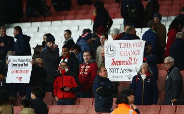 Arsenal fans hold banners after the Barclays Premier League match between Arsenal and West Bromwich Albion.