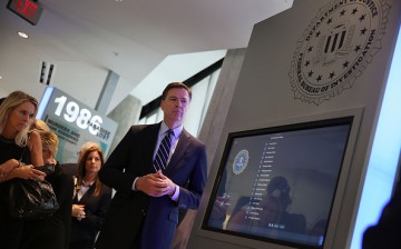 FBI Director James Comey looks on at a memorial built in the lobby of the Miami Field Office including a list of agents killed on duty in a gun battle with two heavily armed suspected bank robbers in 