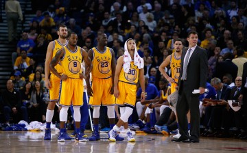 Golden State Warriors players and assistant coach Luke Walton stands on the court.