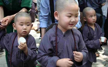 Kids wearing Buddhist clothing take part in an event of 
