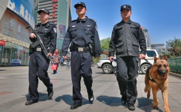 Police officers and a dog patrol a street on May 12, 2014 in Beijing, China.