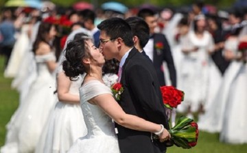 Sealed with a kiss: A newlywed couple share a kiss during a huge wedding held at Zhejiang University on April 30.