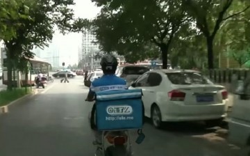 To the rescue: Restaurants in China cater to college students who can’t go out of their campus through their food delivery service. (Above) A delivery guy heads to his next customer.