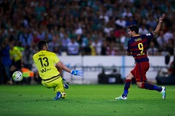 Barcelona striker Luis Suárez scores against Real Betis goalkeeper Antonio Adan.