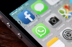 The Facebook and WhatsApp app icons are displayed on an iPhone 