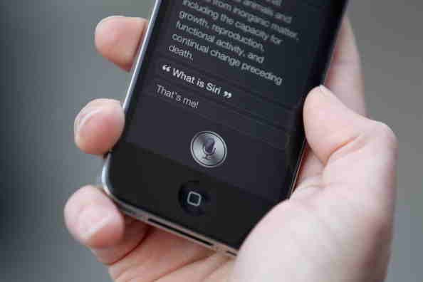 A man uses 'Siri' on the iPhone 4S after being one of the first customers in the Apple store in Covent Garden in 2011.   
