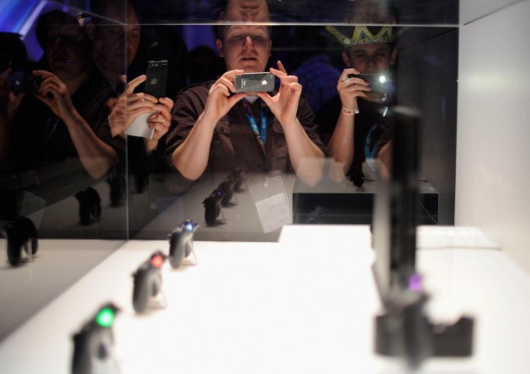 People take photos of a Sony Playstation 4, not the PlayStation NEO, and its controllers on display