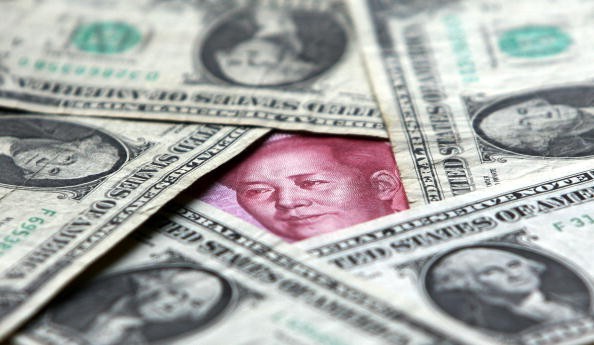  Dollars and yuan notes are seen at a bank on May 15, 2006, in Beijing, China. 