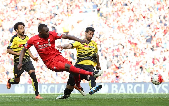 Liverpool striker Christian Benteke (middle) shoots against two Watford defenders.