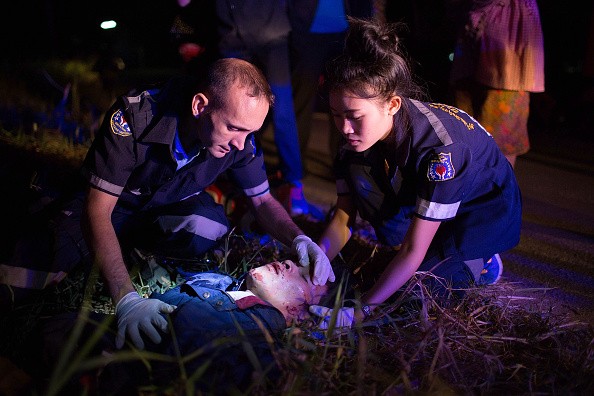 Volunteers treat a severely injured motorbike accident victim on the side of the road