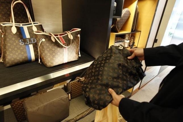 A customer looks at a fake luxury bag allegedly bought and shipped from a Chinese online store.