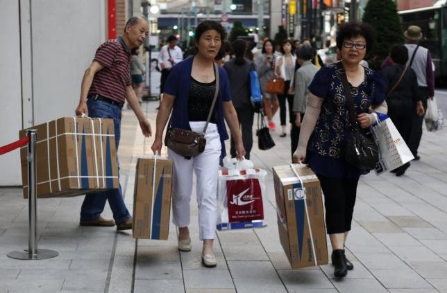 Chinese tourists carry packages of Panasonic Corp.'s washlet along Tokyo's Ginza Shopping District on May 16, 2014.