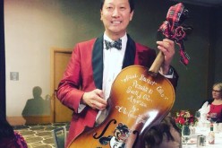 Santa Ono, the University of Cincinnati president who admitted his past battle with depression stands with his best trophy ever, a Cello trophy.