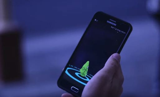 A player catches Metapod on Pokémon GO in the public