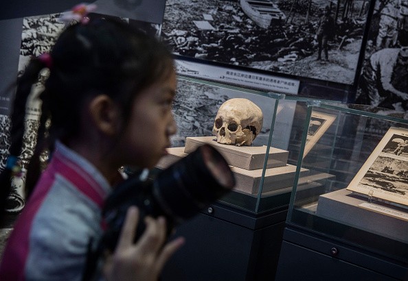  A Chinese girl walks past a skull said to be that of a villager killed by Japanese troops in the Second World War during a visit to a WWII museum on Sept. 1, 2015 in Beijing, China.
