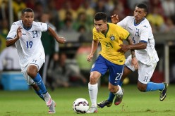 Brazil midfielder Philippe Coutinho (middle) dribbles past two Honduran defenders.