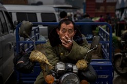 A Chinese laborer smokes a cigarette at a local market on Sept. 26, 2014 in Beijing, China. 