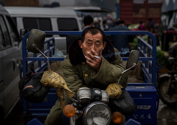 A Chinese laborer smokes a cigarette at a local market on Sept. 26, 2014 in Beijing, China. 