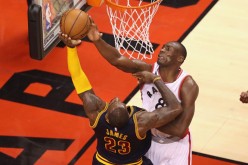 Toronto Raptors center Bismack Biyombo blocks Cleveland Cavaliers' LeBron James.