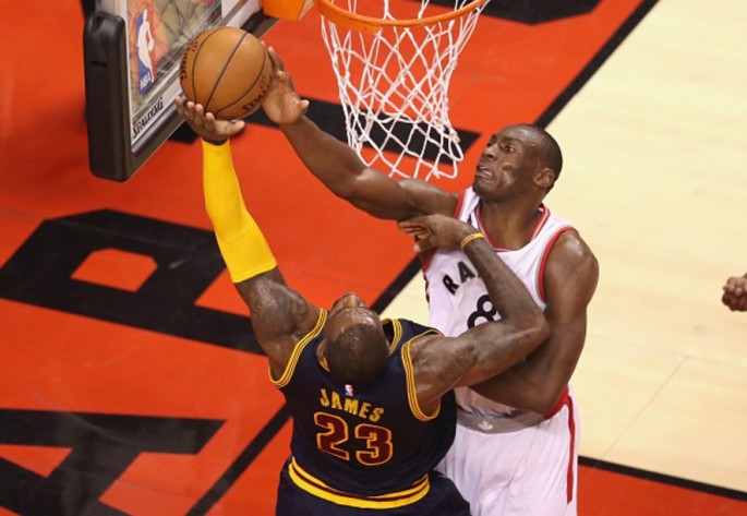 Toronto Raptors center Bismack Biyombo blocks Cleveland Cavaliers' LeBron James.