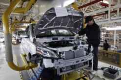 A worker checks an electric car in an EV manufacturing plant in Beijing.
